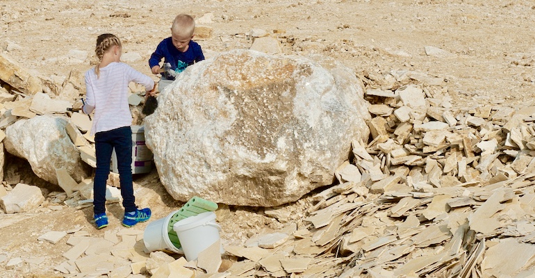 zwei Kinder im Steinbruch auf der Suche nach Fossilien